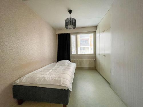 a small bedroom with a bed and a window at Ground floor 3 bedroom apartment, free parking in Oulu