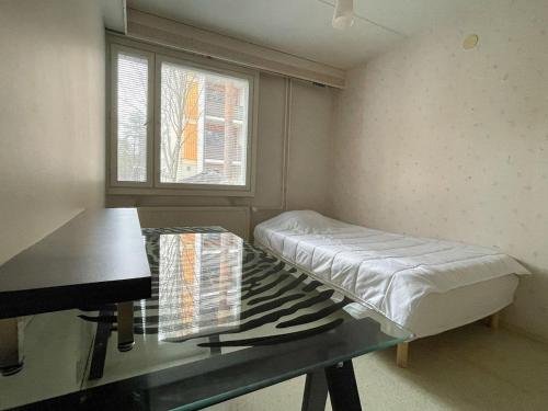 a room with a bed and a table and a piano at Ground floor 3 bedroom apartment, free parking in Oulu