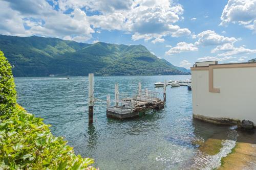 a dock on a lake with boats in the water at Piccola Como Lotus by Rent All Como in Carate Urio