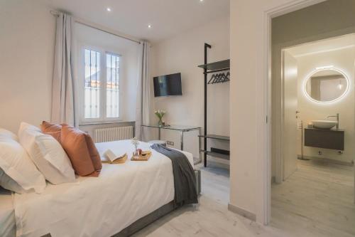 a bedroom with a large white bed and a window at Cernobbio Dream Suites by Rent All Como in Cernobbio