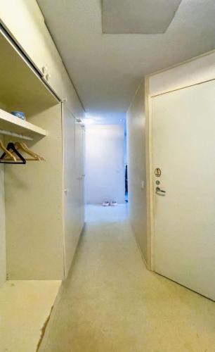 an empty hallway with a white door and a room at Ground floor 3 bedroom apartment, free parking in Oulu