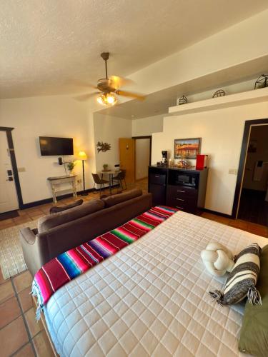 a living room with a large bed and a couch at Adobe Rose Boutique Inn in Artesia