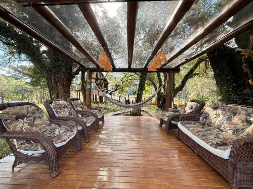 a group of wicker chairs sitting on a wooden deck at Casa na Árvore em Guarapuava in Guarapuava