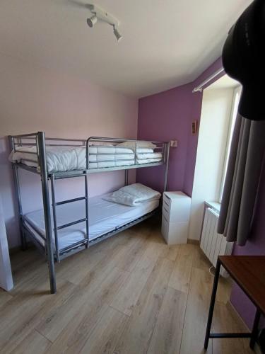 a bedroom with two bunk beds in a room at Le Nid du Haut in Saint-Nectaire