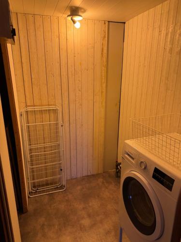 una lavanderia con lavatrice accanto a un muro di Rensjön Guesthouse a Herräng
