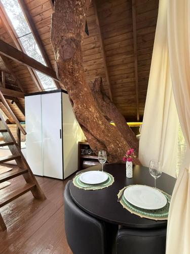 a dining room with a table and a tree at Casa na Árvore em Guarapuava in Guarapuava