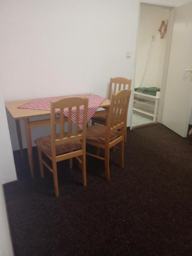 a dining room table with two chairs and a table with a pink table cloth at Hospůdka a Penzion u Rážů in Suchovršice