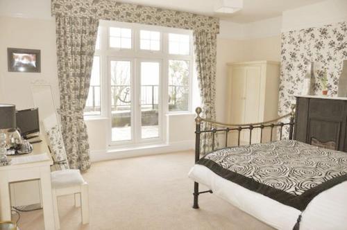 a bedroom with a bed and a desk and a window at The Quay Inn in Minehead