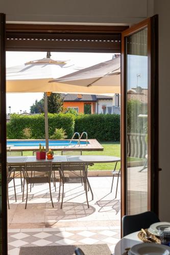 a patio with a table and an umbrella at Trilocale con piscina in Caprino Veronese