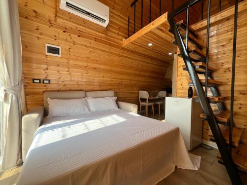 a bedroom with a bed and a wooden wall at Doel House Zues in Shkodër