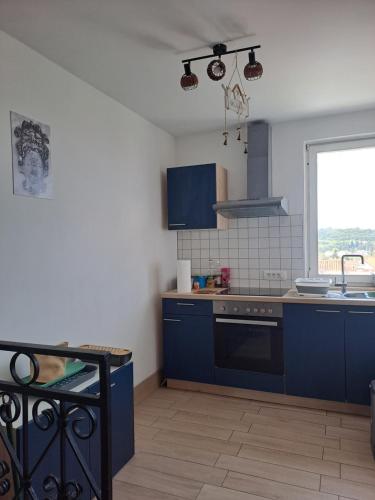 a kitchen with blue cabinets and a sink and a window at APARTMENT RAFAELLO in Portorož