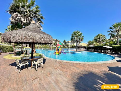 a pool with a table and chairs and a playground at Resort VG SUN por Be My Guest! in Caucaia
