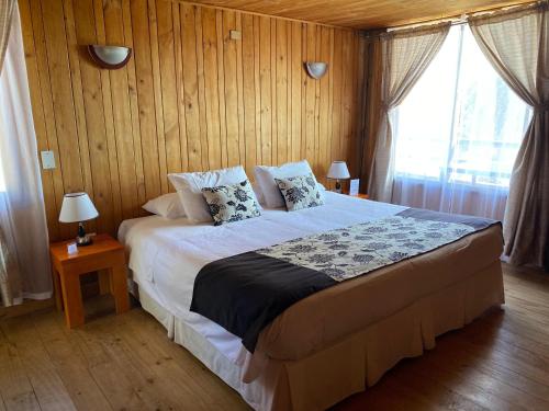 a bedroom with a large bed with wooden walls at Hotel Green Papudo in Papudo