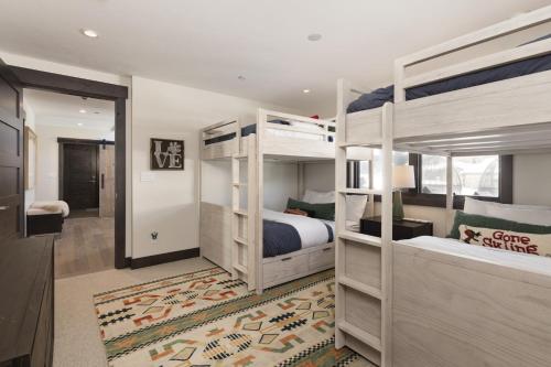 a bedroom with two bunk beds and a hallway at Spanish Peaks | Highlands Cabin 36 in Big Sky