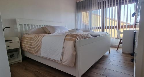 a bedroom with a bed and a large window at Apartamentos Les Texuques in Nueva de Llanes