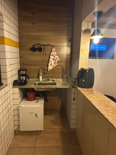 a small kitchen with a sink and a counter at Chalé Jorge in São Thomé das Letras