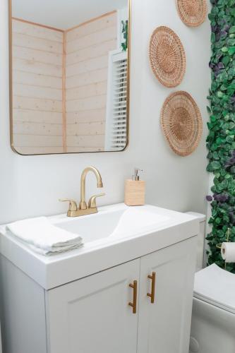 a bathroom with a white sink and a mirror at Pelican's Perch in Downtown EGAD in Melbourne