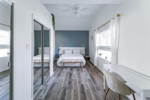 a white bedroom with a bed and a mirror at Pelican's Perch in Downtown EGAD in Melbourne