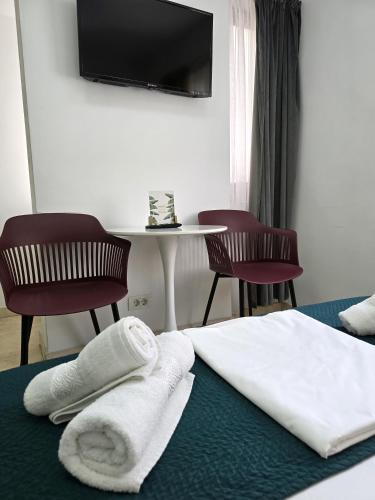 a hotel room with a bed with two chairs and a table at Dacia Residence Apartments in Bucharest