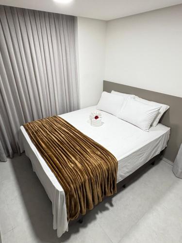 una camera da letto con un letto con una coperta sopra di Melhores Flats - Jacuzzi privativa, beira-mar a Cabedelo
