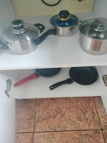 two pots and pans on a shelf in a kitchen at Anaga y La laguna a tus pies in Santa Cruz de Tenerife