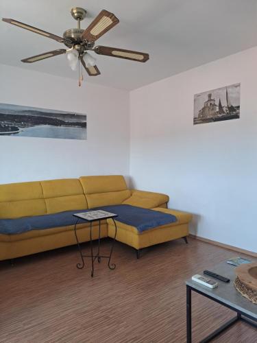 a living room with a couch and a ceiling fan at APARTMENT RAFAELLO in Portorož