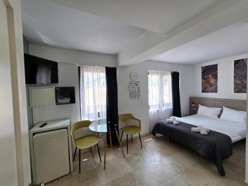 a bedroom with a bed and a table and chairs at Dacia Residence Apartments in Bucharest