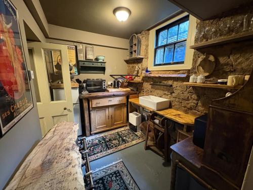 cocina con encimera y pared de piedra en The Writers Den, en Nairn