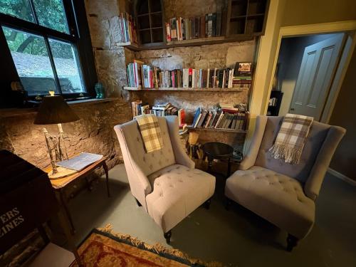 Una sala de estar con dos sillas y una mesa. en The Writers Den, en Nairn