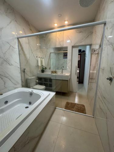 a bathroom with a tub and a shower and a sink at Casa Canto do Araguaia in Barra do Garças