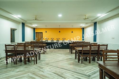 a conference room with wooden tables and chairs at Happy Adventure Camp & Resort Sam Jaisalmer in Sām