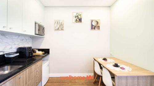 a kitchen with a wooden table and a counter top at Studio em Cotia com piscina e lazer completo in Cotia