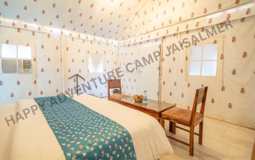 a bedroom with a bed and a table and a desk at Happy Adventure Camp & Resort Sam Jaisalmer in Sām