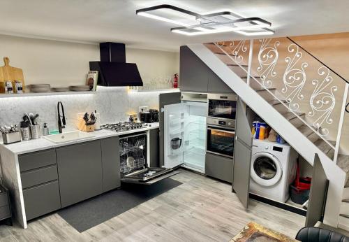 a kitchen with a sink and washing machines and a staircase at Rome Castle House with Meals Wine and Spirits in Civitella San Paolo