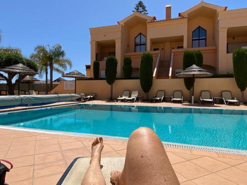a man laying on the edge of a swimming pool at Praia da Luz - Resort in Luz