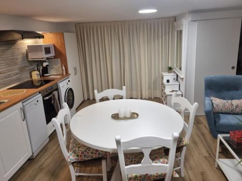 a kitchen with a white table and chairs in a room at La Casita de Paula in Mairena del Aljarafe