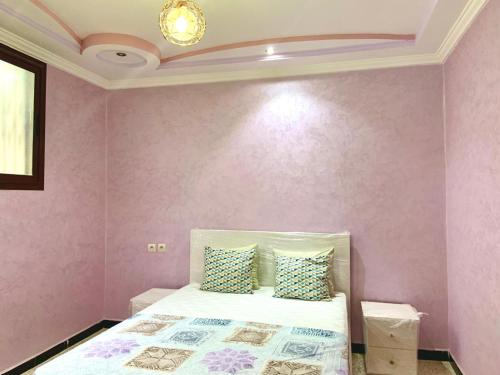 a bedroom with a bed with a pink wall at Grand Appartement Luxueux En Plein Taroudant in Taroudant