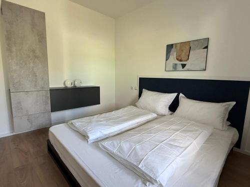 un dormitorio con una cama con sábanas blancas en Appartement bis 3 Personen gehobene Ausstattung, en Bad Münder am Deister