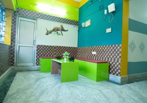a room with two tables and a dinosaur on the wall at Binay chapa homestay in jaldapara in Mādāri Hāt