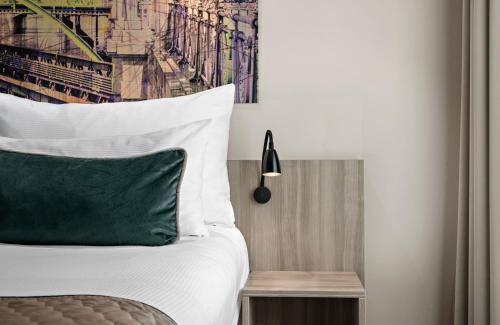 a bedroom with a bed with a green pillow at Leonardo Hotel Vienna City West in Vienna