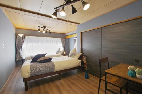 a bedroom with a bed and a table in it at VILLENT Atagawa Terrace - Vacation STAY 28115v in Okawa