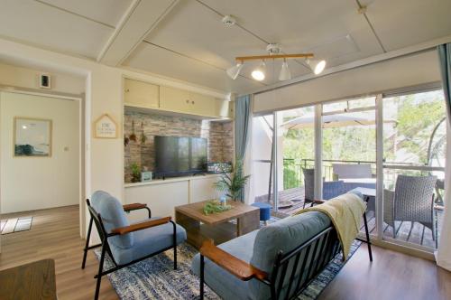 a living room with a couch and a tv at VILLENT Atagawa Terrace - Vacation STAY 28115v in Okawa