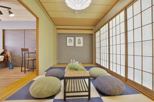 a living room with a table and chairs and windows at VILLENT Atagawa Terrace - Vacation STAY 28115v in Okawa