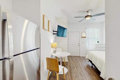 a white bedroom with a bed and a table and a chair at Bowen Village 2118B in Charleston