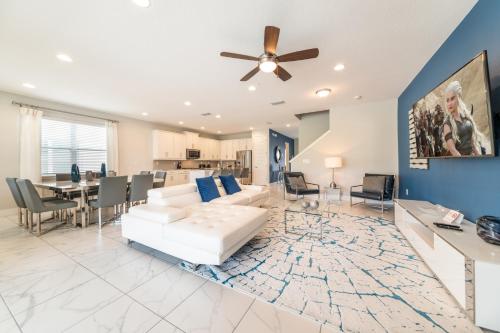 a living room with a white couch and a ceiling fan at Magnificent Home Near Disney With Theater Room, Pool Table, Waterpark & Resort Access At Encore Resort Reunion - 7448Mr in Kissimmee