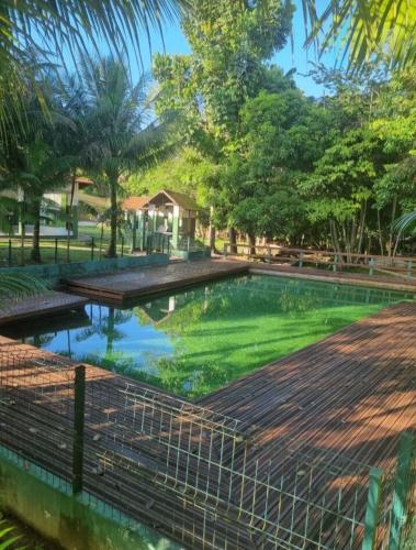 une piscine d'eau verte avec une maison en arrière-plan dans l'établissement Apartamento Safira Park Cop30, à Belém