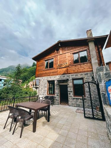a wooden house with a table and chairs on a patio at A Peaceful Base for Exploring the Magic of Rize in Dikkaya