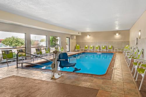 a pool with chairs and tables in a hotel room at Comfort Inn & Suites Kansas City - Northeast in Kansas City