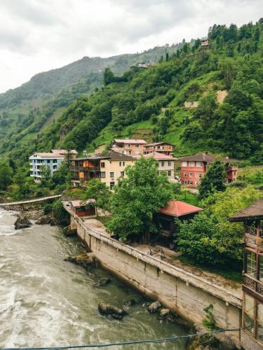 a group of houses on a hill next to a river at A Peaceful Base for Exploring the Magic of Rize in Dikkaya