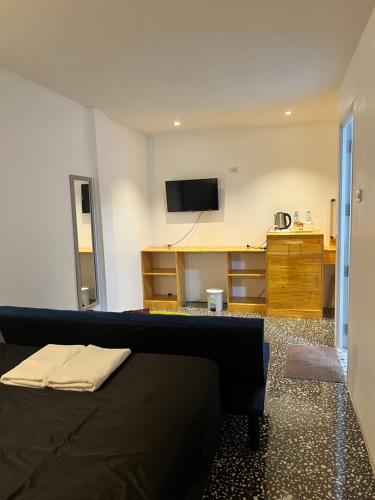 a room with a bed and a tv on a wall at Yok Guesthouse Jomtien in Jomtien Beach